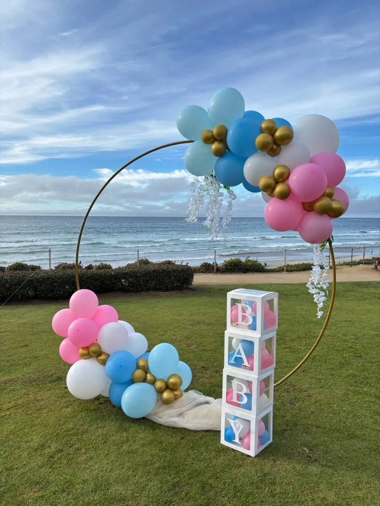 Gender reveal baby shower balloon hoop by the ocean in San Diego
