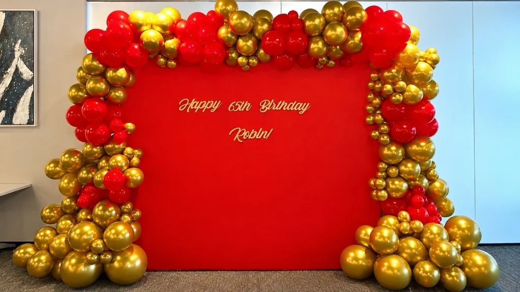 Red and gold balloon garland for 65th birthday